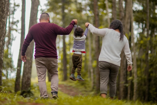 family of 3 walking through the park